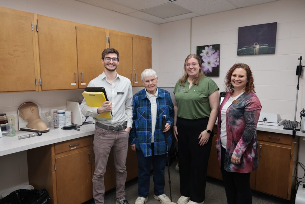 Audiology students and faculty member in a lab with a hearing client.