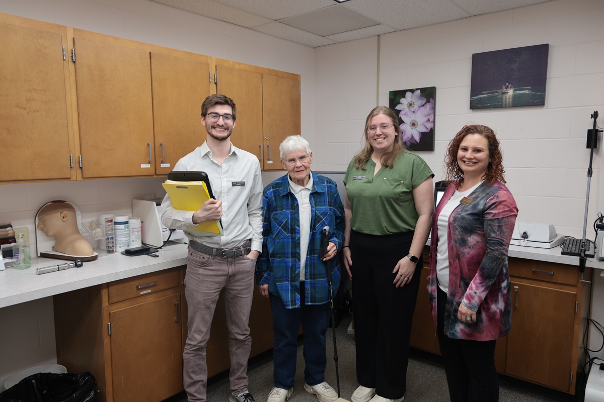 Audiology students and faculty member in a lab with a hearing client.