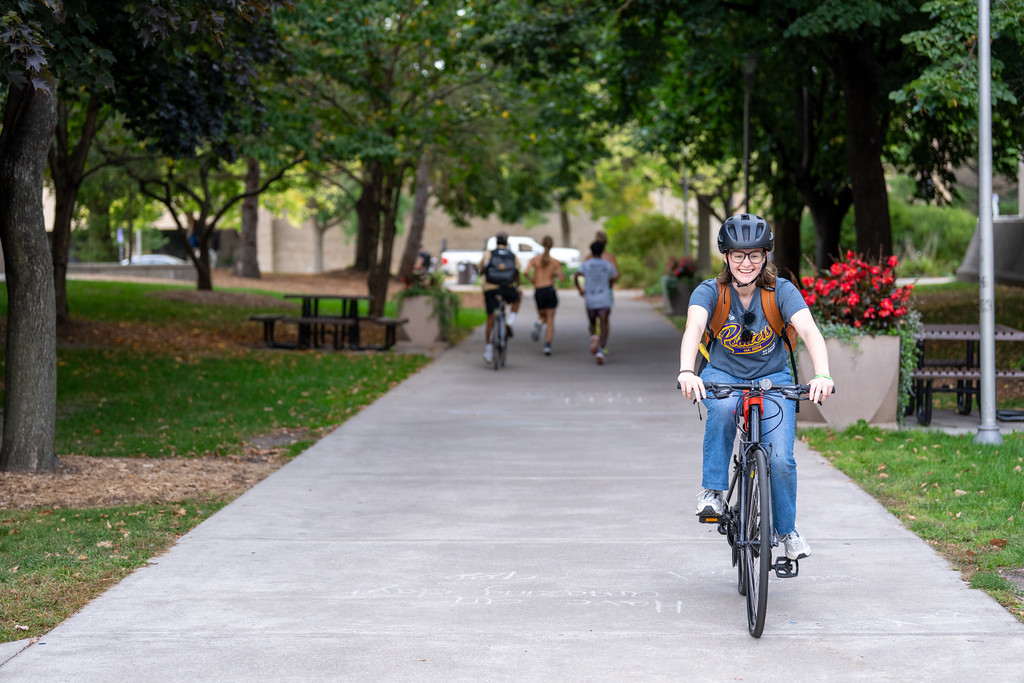 student riding bike through campus
